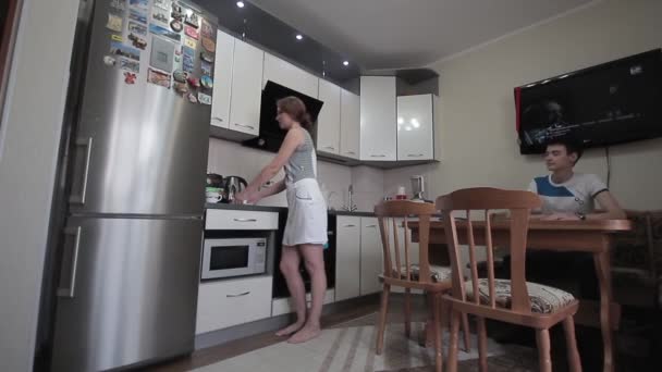 Een meisje en een jongen in de keuken — Stockvideo