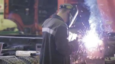 Koruyucu maskeli, kaynak yapan bir işçi.