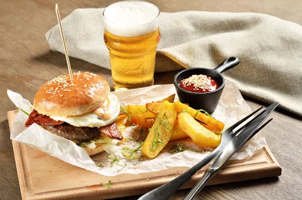 Burger, mexican potatoes and ketchup on wooden board — Stock Photo, Image