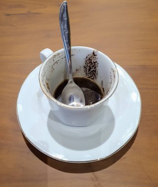 Bir fincan demlenmiş kahve bitmiş ve kahve telvesi bırakılmış.