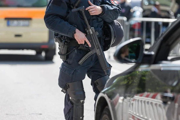 german policeman with machine gun doing security control
