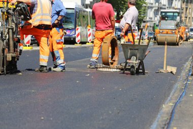 Kürekli işçiler yol yüzeyini yeniliyor