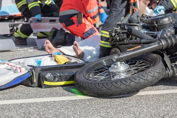 Rescue workers help the victim of a motorcycle accident