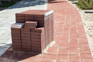 Yeni yapılmış bir döngü yolunda kırmızı beton bloklar yığını duruyor.