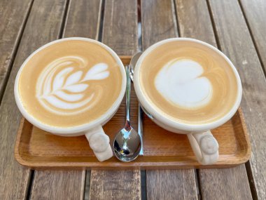 Tahta tepside iki bardak kapuçino.