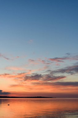 Gün batımının arkaplanındaki bulutlar nehir kıyısında