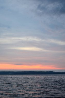 Akşam bulutlu ufuk gün batımında aydınlanıyor.