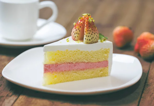 Primo piano di torta alla crema di fragole su bianco sul backgroun di legno — Foto Stock