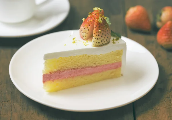 Primo piano di torta alla crema di fragole su bianco sul backgroun di legno — Foto Stock