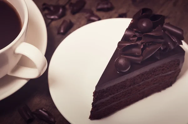 Pastel de chocolate cubierta con rizo de chocolate sobre fondo de madera, v — Foto de Stock