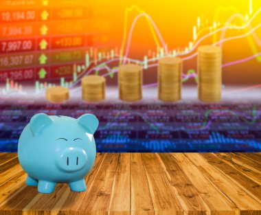 blue pig bank on wood background with blur stock market backgrou clipart