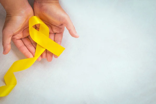 Händerna Håller Gult Band Med Kopieringsutrymme Bencancer Sarkom Medvetenhet Barncancer — Stockfoto