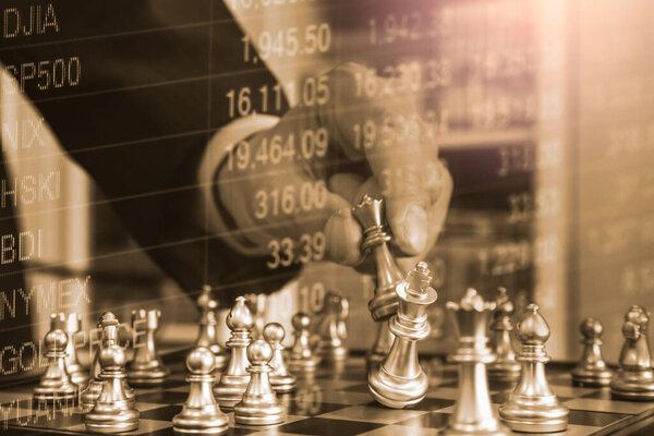 Chess game on chess board behind business man background. Business concept to present financial information and marketing strategy analysis. Investment target in global economy and digital commercial.