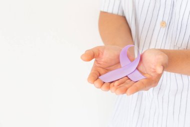 Beyaz arka planda açık mor kurdele tutan eller, kopyalama alanı. Testis kanseri farkındalığı, Alzheimer hastalığı, epilepsi farkındalığı, Dünya Kanser Günü. Sağlık hizmetleri ya da hastane ve sigorta kavramı.