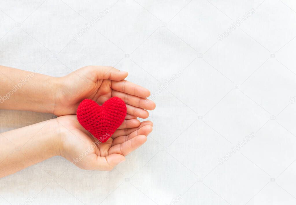 Hands holding red heart on white isolated background, copy space, concept of love, hope,healthcare,organ donation,insurance and CSR, World heart day, National Organ Donor day,World mental heath day.