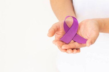 Beyaz arkaplanda mor ya da mor kurdele tutan eller, kopyalama alanı. Pankreas kanseri, Testis kanseri farkındalığı, kanserden kurtulma, leyomiyosarkom, Dünya Kanser Günü. Sağlık sigortası, sigorta kavramı.