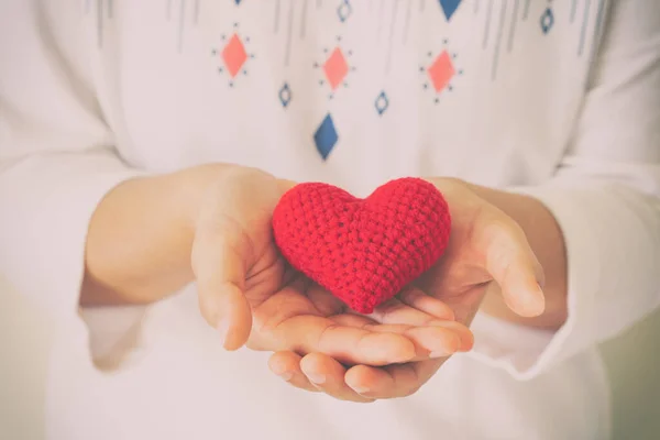 Women wear knit shirt hand holding red heart. Concept of love, hope, happy valentine, healthcare,organ donation,insurance, medical, World heart day, National Organ Donor day,World mental health day.