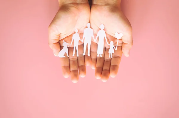 Hand Hält Familienpapier Auf Rosa Hintergrund Geschnitten Familientag Konzept Pflege — Stockfoto