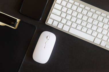 Laptop, akıllı telefon ve bir fincan kahveli diğer iş malzemeleri olan siyah masa ofisi. Metni kopyalamak için üst görünümü kullan. Desenci çalışma alanı düz masa üzerinde temel elementler yatıyordu.