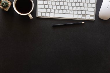 Laptop, akıllı telefon ve bir fincan kahveli diğer iş malzemeleri olan siyah masa ofisi. Metni kopyalamak için üst görünümü kullan. Desenci çalışma alanı düz masa üzerinde temel elementler yatıyordu.