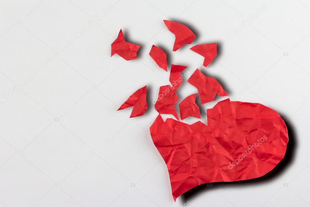 close up of paper broken heart on white background