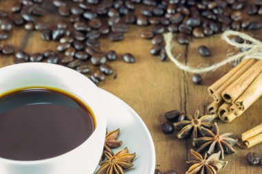 Kahve Kupası kahve çekirdekleri ve tarçın ile ahşap üzerine yapışıyor