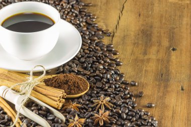 Kahve Kupası kahve çekirdekleri ve tarçın ile ahşap üzerine yapışıyor