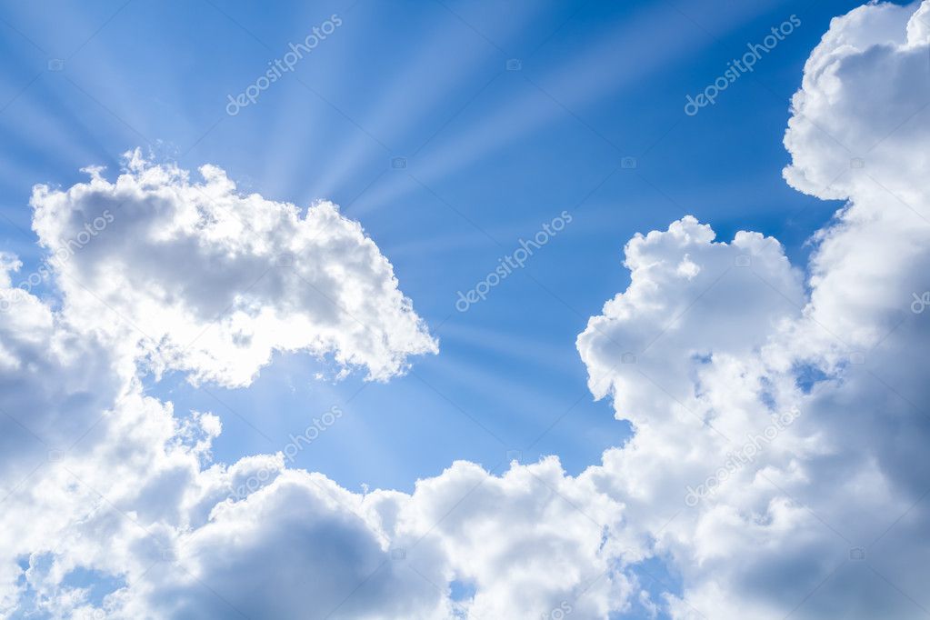 sun rays breaking through the clouds on blue sky