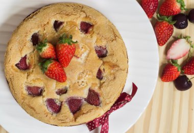 Çilekli tereyağı pasta plaka üzerinde geri ahşap üzerine çilek ile