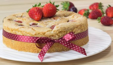 Çilekli tereyağı pasta plaka üzerinde geri ahşap üzerine çilek ile