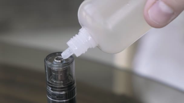 Elektronische Zigarette per Hand mit E-Liquid in einer Flasche aufladen — Stockvideo