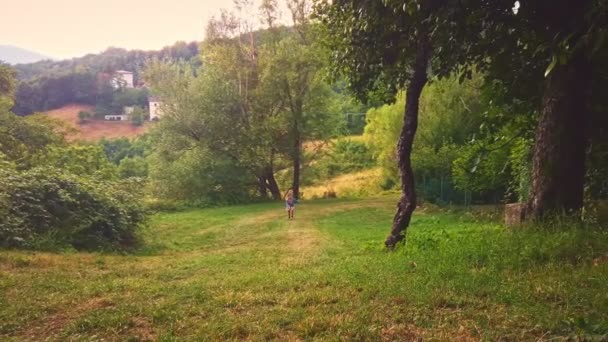 Bardzo szczęśliwa dziewczyna biegnie do kamery w kolorowy trawnik lub ogród — Wideo stockowe