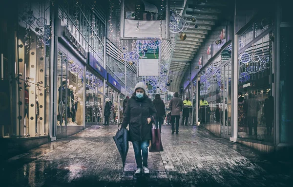 2020 ekonomik krizi, alışveriş merkezinde maskeli bir kadın Noel döneminde Covid-19 salgınında yürüyor. — Stok fotoğraf