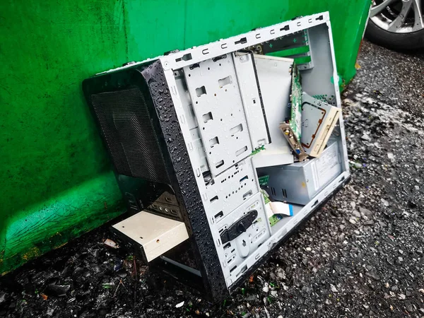 computer dumping waste - old pc abandoned on wet road background