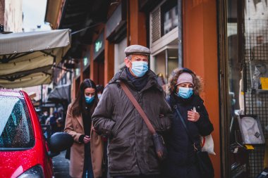 Yaşlı çift yaşlı kadın, Bolonya 'da Covid-19 salgını sırasında İtalyan sokaklarında maske takıyor.