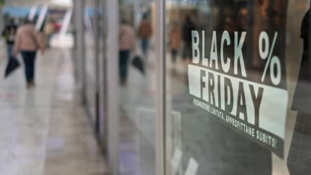 Letrero de viernes negro en el fondo de pantalla de la tienda en un centro comercial con gente caminando — Vídeos de Stock