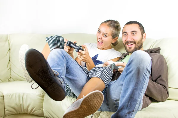 Pareja se emociona divirtiéndose jugando videojuegos en el sofá —  Fotos de Stock