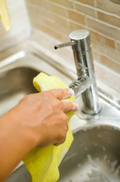 Mujer mano haciendo tareas en la cocina en casa, fregadero y grifo — Foto de Stock