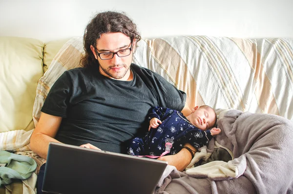 Tired young father take care of baby while trying to work at not — Stock Photo, Image