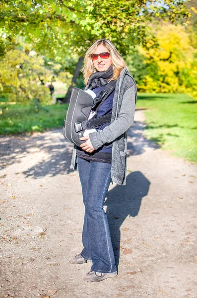 Baby carrier rucsac în parc — Fotografie, imagine de stoc