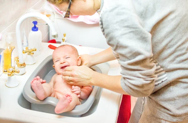 Babák crying, míg anyja fürdő fürdőszoba mosogató medence - newbo — Stock Fotó