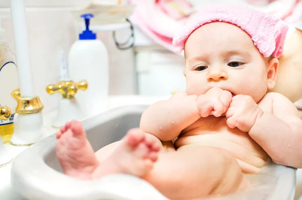 Újszülött baba veszi fürdő mosogató medence törölköző rózsaszín fej kezek punch m — Stock Fotó