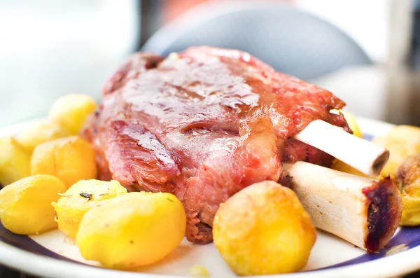 Varkensvlees schacht met gele cirkel aardappelen — Stockfoto