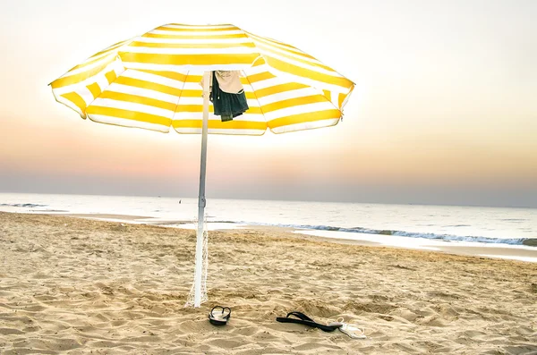 Parasol jaune solitaire sur la plage au coucher du soleil dans les Pouilles — Photo