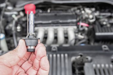 Arabanın farlarını kapat, Xenon Işıklandırma Ekipmanı elinde. Motor dairesi olan bir adam araba bakım konsepti için.