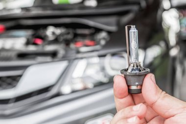 Arabanın farlarını kapat, Xenon Işıklandırma Ekipmanı elinde. Motor dairesi olan bir adam araba bakım konsepti için.