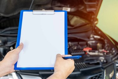 Araç hizmet merkezinin çalışanları bakım ve servis arabası için kağıt notları kontrol ediyorlar.