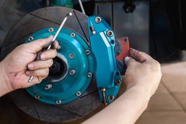 Calliper frenini kapat ve el teknisyeni fren pedlerini calliper ve ingiliz anahtarına takıyor: servis konsepti