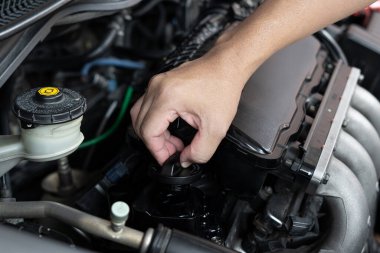 Araba teknisyeni, motor odası servisi ve bakım konseptinde tornavida sökme sürgüsü kullanıyor. 