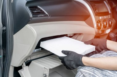 Kadın sürücü soğutma sistemindeki hava filtresini tek başıma kaldırdı. Araç servisi konseptinde toz ve arızayı kontrol ettim. 